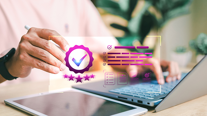 Close-up of hands using laptop with digital quality check badge, checklist, and rating icons overlay. Concept of certification, business standards, and product evaluation.