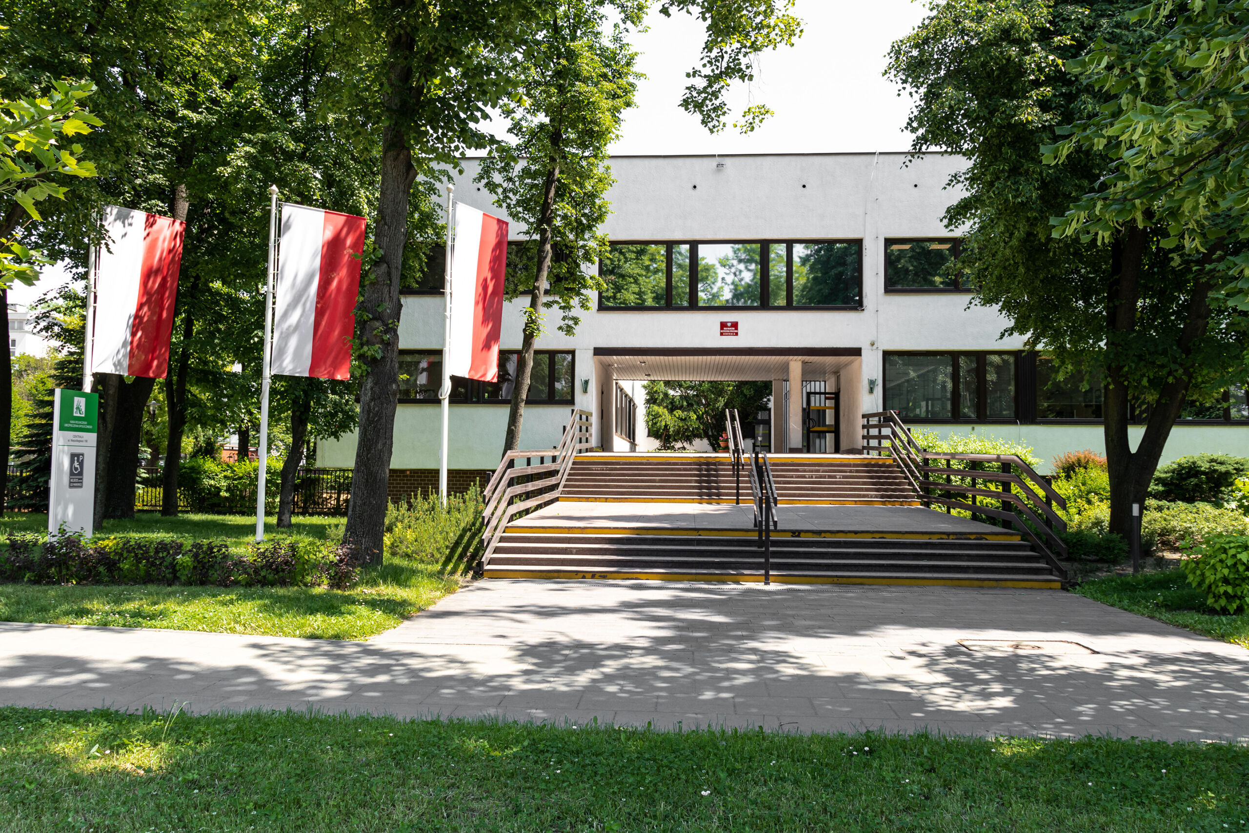Entrance of a public building in Poland with three Polish flags.